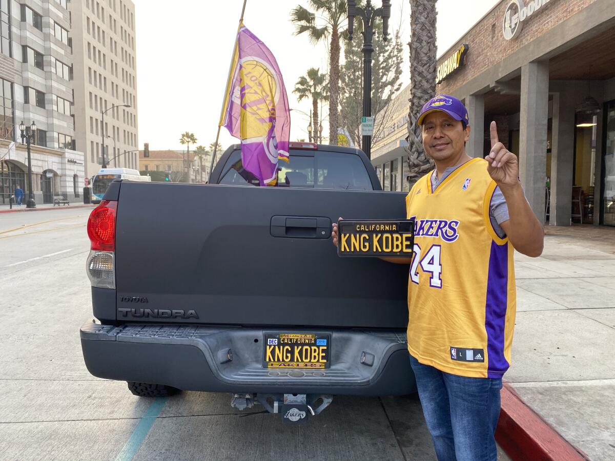 Ron Bonilla stands behind his truck that features a KNG KOBE license plate and a Lakers flag at half-staff.