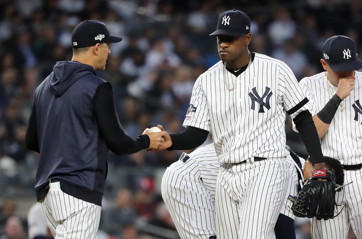 Aaron Boone, left, takes the ball from Luis Severino