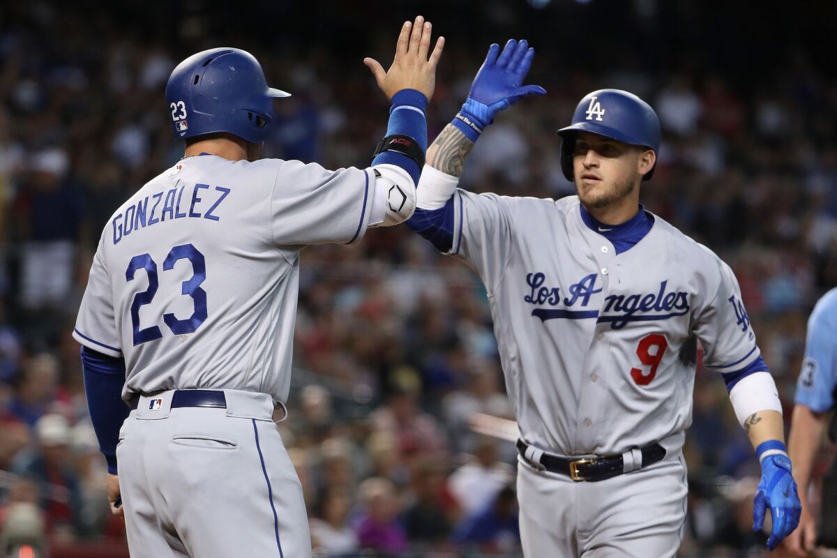 Dodgers catcher Yasmani Grandal (9) high fives Adrian Gonzalez (23) after Grandal hit a two-run home run against the Arizona Diamondbacks during the fifth inning on April 23.
