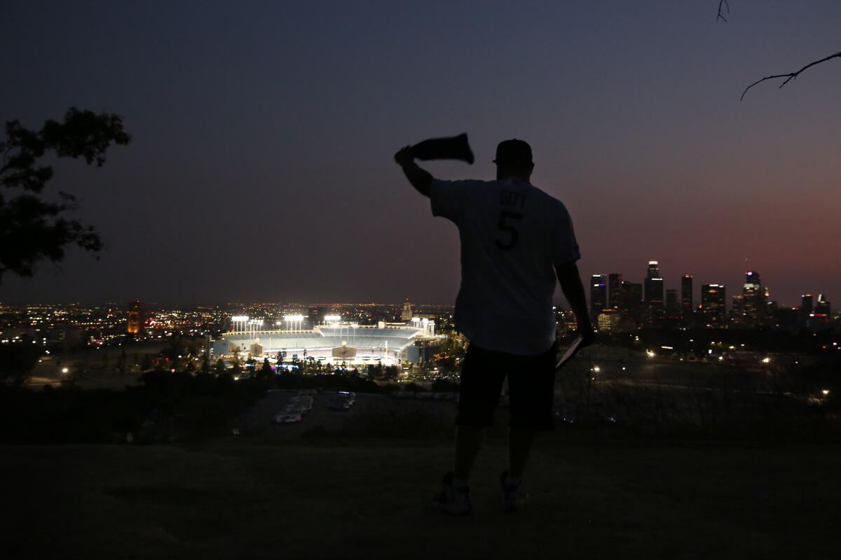 Josh Gitt waves a bandanna while watching the Dodgers play the Milwaukee Brewers from a distance outside Dodger Stadium.