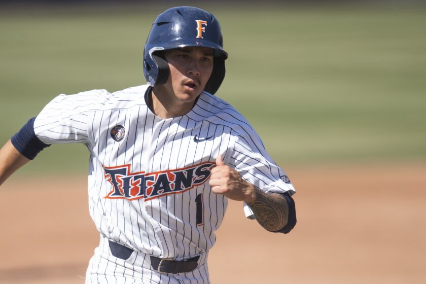Cal State Fullerton third baseman Zach Lew rounds third base to score.