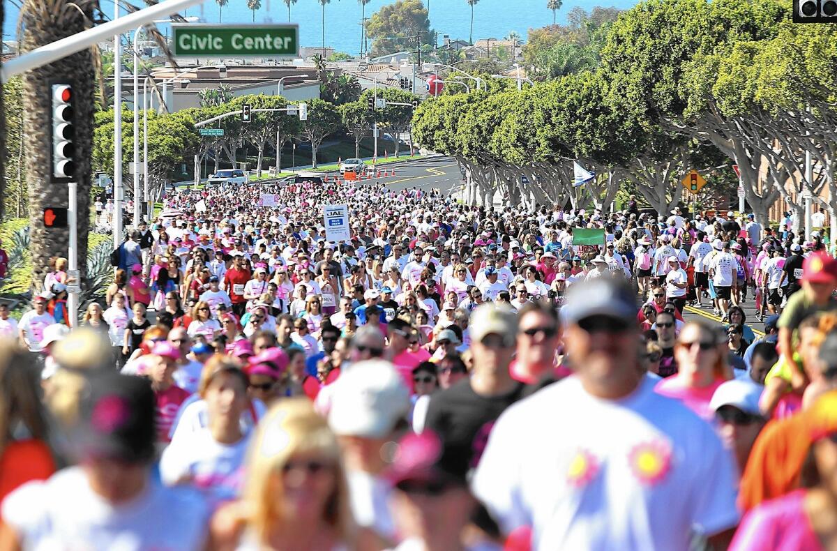 A mass of participants fill and walk up Avocado St. as they walk in the 5K run/walk event in the 2014 Susan G. Komen Race for the Cure at Fashion Island in Newport Beach.