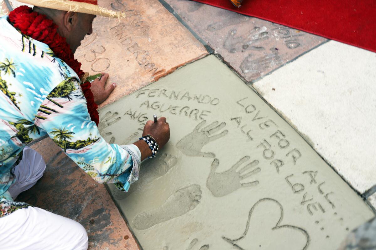 Fernando Aguerre signs his name in cement outside the Surfers' Hall of Fame. 