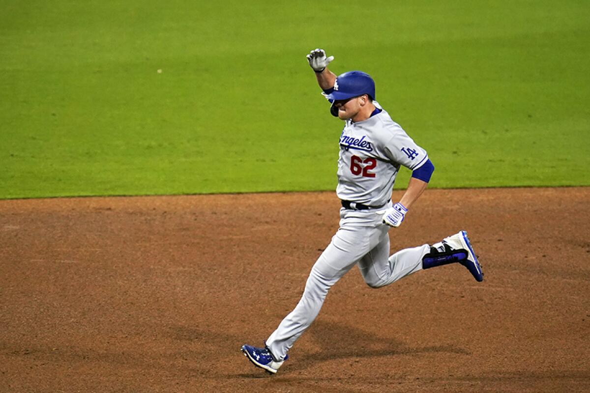 The Dodgers' Luke Raley raises a hand as he runs.