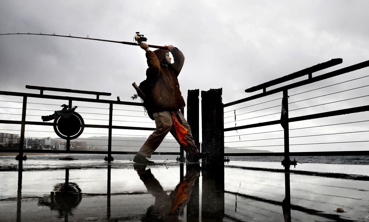 Antonio Sanchez, 33, of Torrance fishes in the rain at Redondo Beach Pier on Monday.