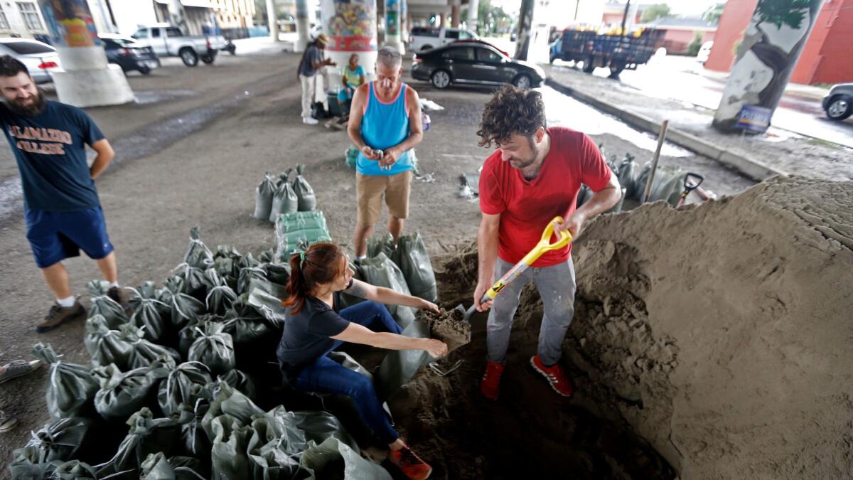 Leah Perry, center, and her husband, Scott, fill sandbags in New Orleans.