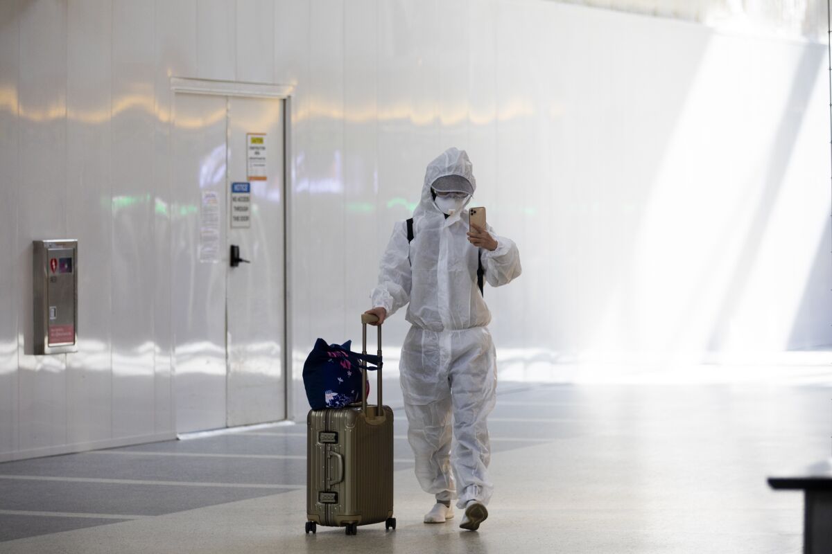 A passenger wearing personal protective equipment walks in the Tom Bradley International Terminal at LAX on November 17.