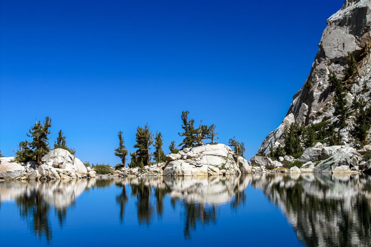 Lone Pine Lake reflects the rocks and mountain. 