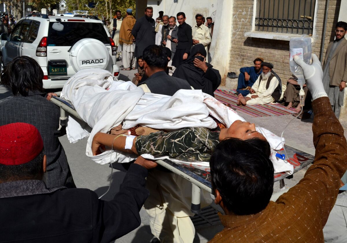 Volunteers carry an injured polio-vaccination worker to a hospital in Quetta, Pakistan, on Nov. 26 after gunmen attacked a vaccination team, killing four.