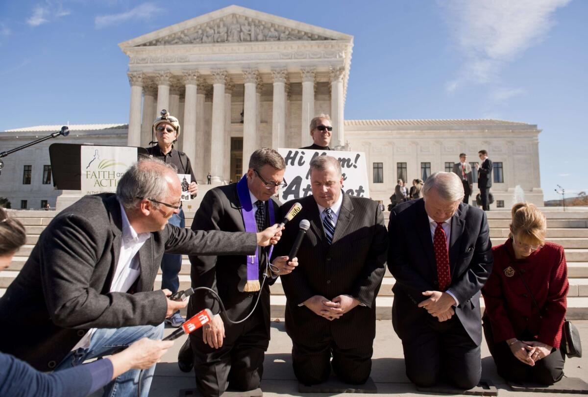 Religious activists pray outside the Supreme Court following oral arguments in the case of Town of Greece vs. Galloway.