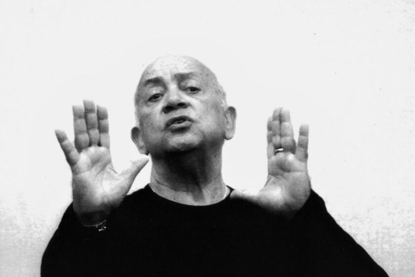 Close up on an older man dressed in black, teaching a dance class