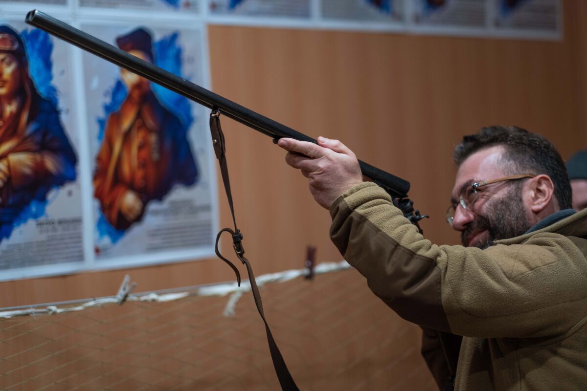 A civilian points a shotgun into the air