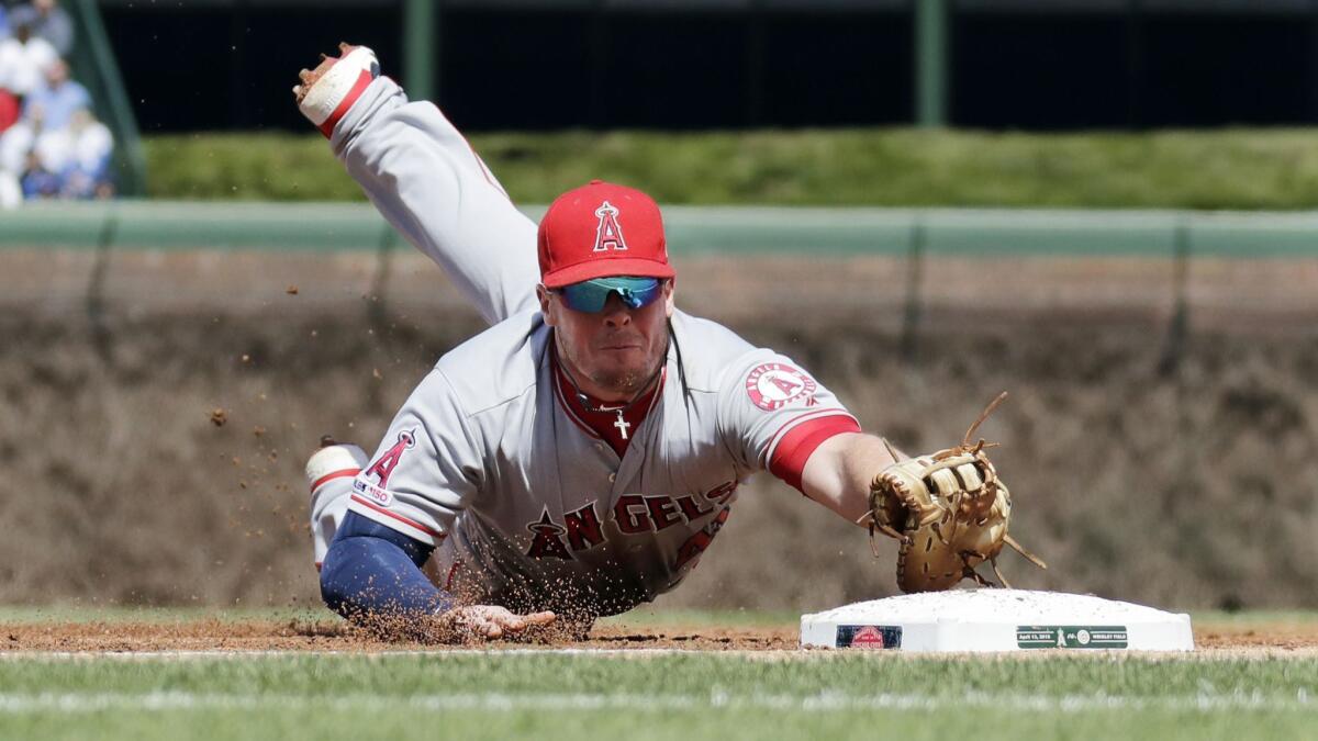 Angels first baseman Justin Bour dives to snag a groundball hit by the Chicago Cubs' Anthony Rizzo during the first inning.