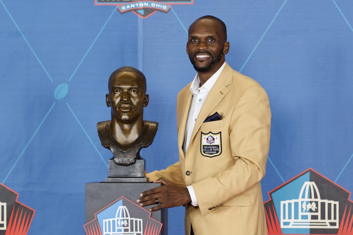 Isaac Bruce poses with his bust during the Pro Football Hall of Fame induction ceremony Aug. 7, 2021, in Canton, Ohio.