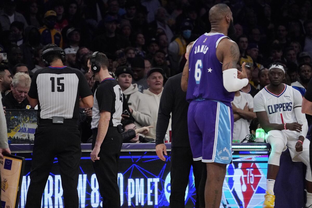 Referees review a call as Los Angeles Lakers forward LeBron James,  