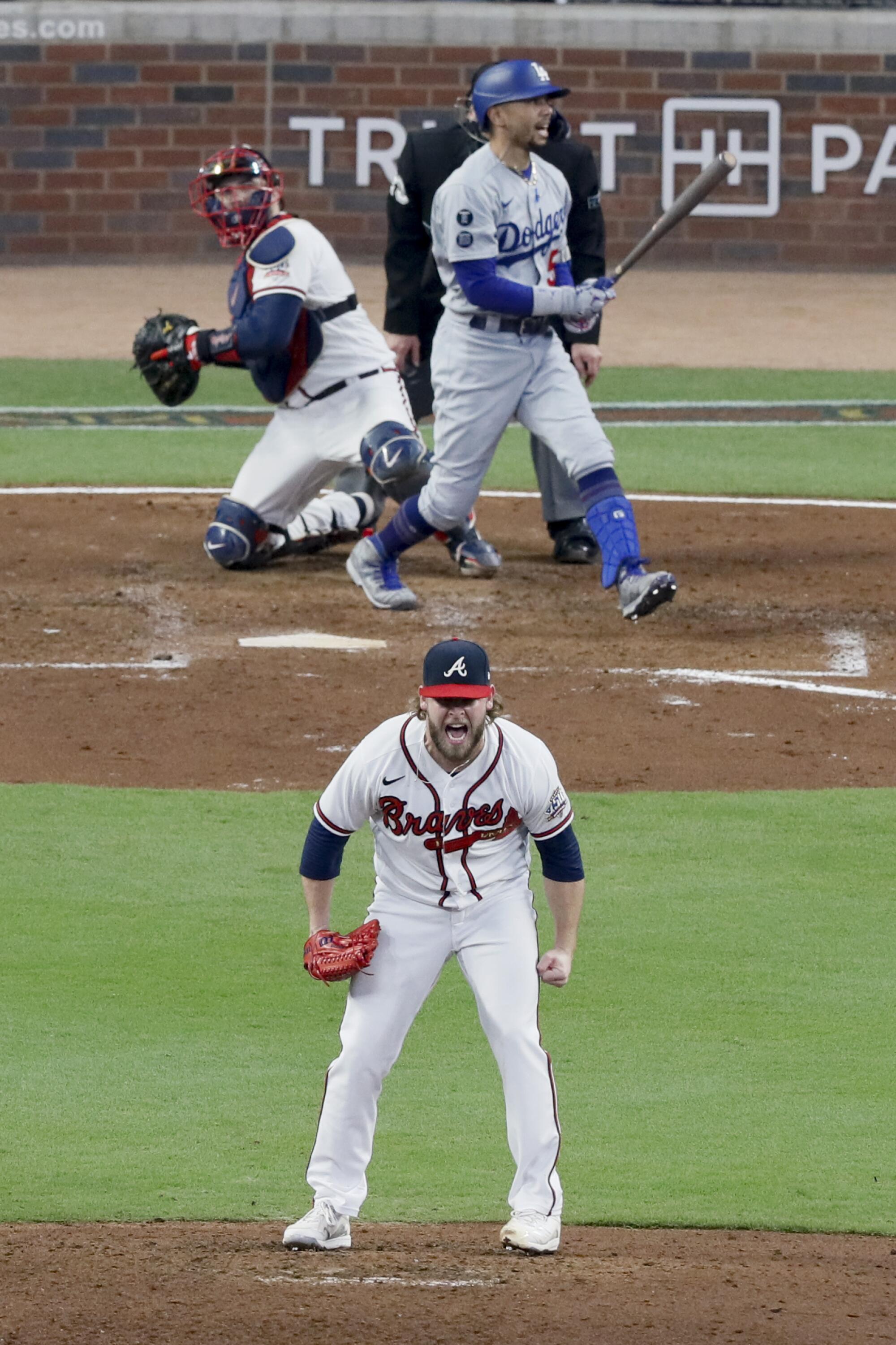 Braves relief pitcher A.J. Minter, bottom, reacts after striking out Mookie Betts.