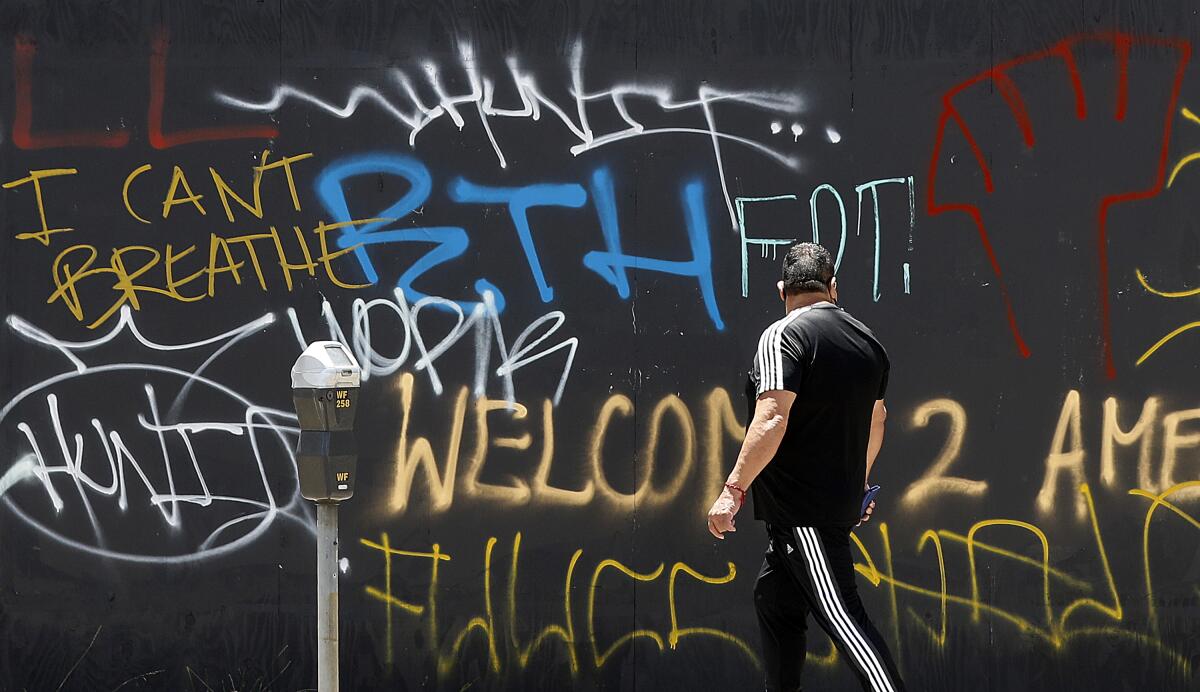 A pedestrian reads protest graffiti on 3rd Street in the Fairfax District on May 31.