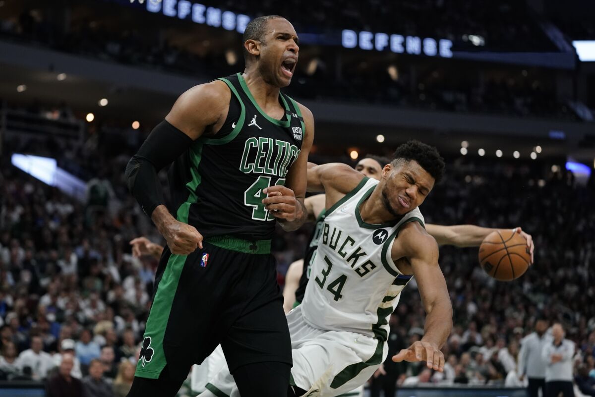 Boston Celtics' Al Horford reacts in front of Milwaukee Bucks' Giannis Antetokounmpo during the second half of Game 4 of an NBA basketball Eastern Conference semifinals playoff series Monday, May 9, 2022, in Milwaukee. The Celtics won 116-108 to tie the series 2-2. (AP Photo/Morry Gash)