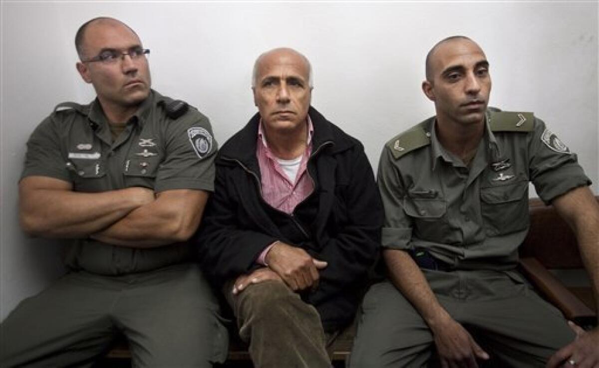 Israeli nuclear whistleblower Mordechai Vanunu, center, sits between two prison guards as he waits in a courtroom before a hearing, in Jerusalem, Tuesday, Dec. 29, 2009. Vanunu was put under house arrest Tuesday after being charged with violating a condition of his 2004 release from an Israeli prison. Vanunu was a former low-level technician at an Israeli nuclear plant who leaked details and pictures of the operation to the Sunday Times of London in 1986. Vanunu served 18-years in prison and after his release was banned from leaving the country and having unauthorized contact with foreigners.(AP Photo/Dan Balilty)