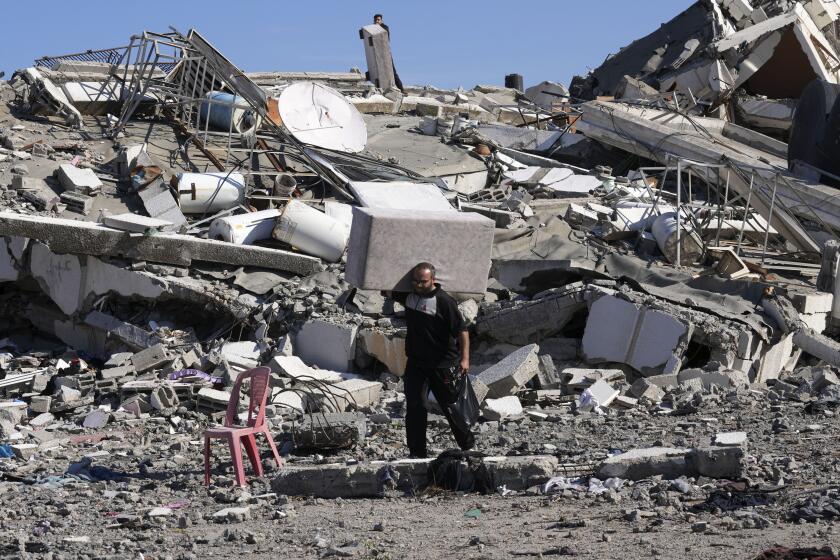 Palestinos visitan sus casas, destruidas en bombardeos israelíes sobre Al-Zahra, a las afueras de la Ciudad de Gaza, el 30 de noviembre de 2023, durante la tregua temporal entre Hamás e Israel. (AP Foto/Adel Hana)