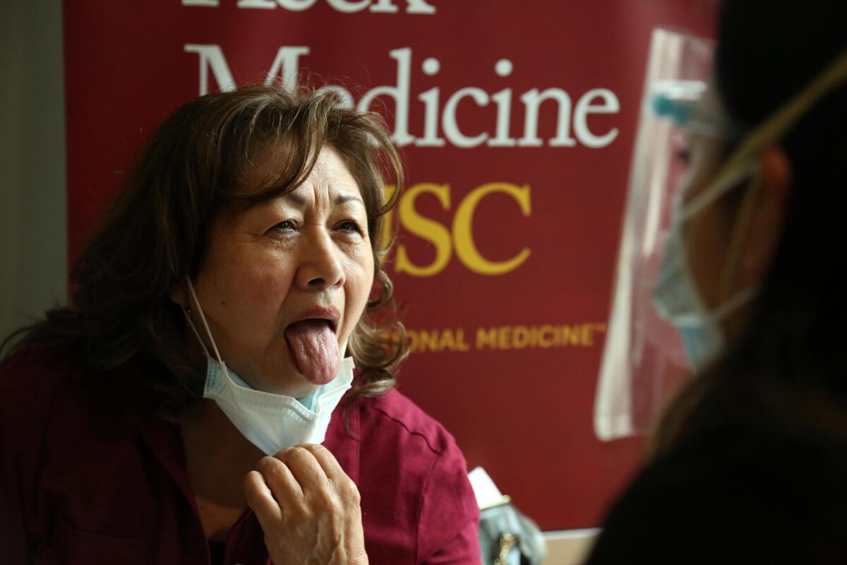 Nidia Salas sticks out her tongue for a nurse