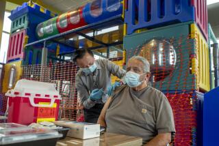 FULLERTON, CA - SEPTEMBER 27: Pharmacist Ryan Le, left, gives Jim Canales, 78, of Fullerton a booster shot of Pfizer-BioNTech vaccine at McDonald's on Monday, Sept. 27, 2021 in Fullerton, CA. Canales says his son is a repertory therapist and tells him he must wear his face mask. The Department of Public Health and McDonald's California franchisees continue pop-up vaccine clinics at locations throughout Southern California. They are offering Pfizer, Moderna, and Johnson & Johnson vaccinations and free menu items to the public. (Francine Orr / Los Angeles Times)