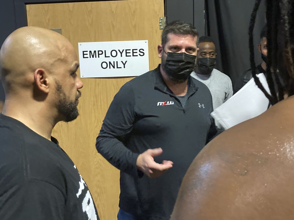 Major League Wrestling CEO Court Bauer, center, goes over the night’s card with wrestlers at 2300 Arena in Philadelphia, Saturday, Oct. 2, 2021. The newest professional athletes to settle in Philadelphia is the roster for Major League Wrestling. MLW is set to make its major cable debut on Thursday night, Oct. 7, 2021. (AP Photo/Dan Gelston)
