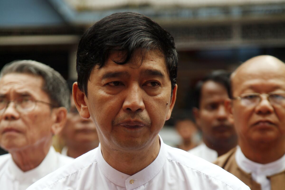 FILE - Min Ko Naing, a leader of Myanmar prominent 88 Generation Student Group, stands up during an inauguration ceremony of a free clinic to mark the 6th month since Win's death, Tuesday, Oct 21, 2014, in Yangon, Myanmar. Myanmar’s military ruling council has announced the revocation of the citizenship of Min Ko Naing and other top members of the main group coordinating resistance to army rule, who in turn dismissed the move with scorn on Saturday, March 5, 2022.(AP Photo/Khin Maung Win, File)