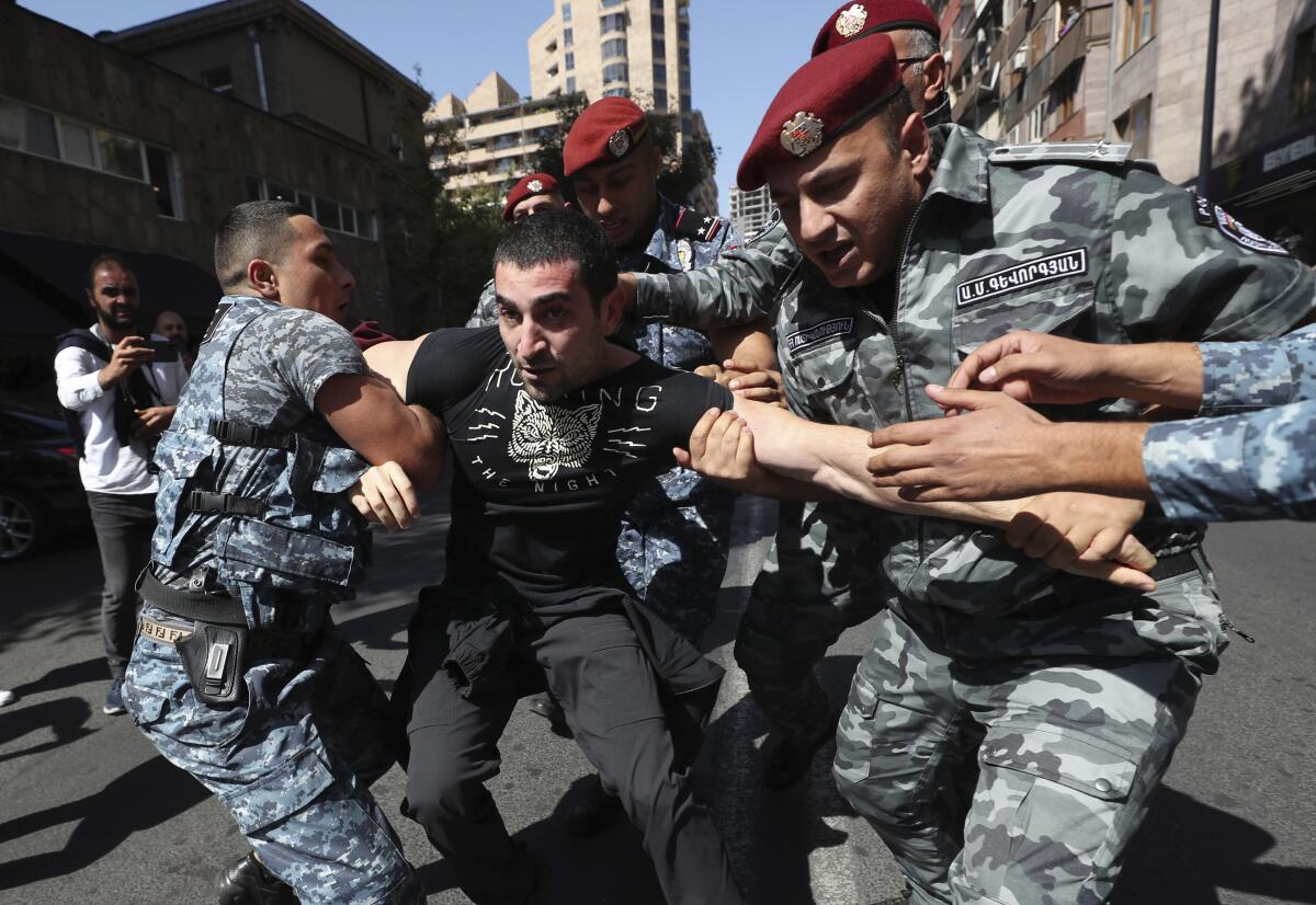 Police officers detain a demonstrator during a protest in Yerevan, Armenia.