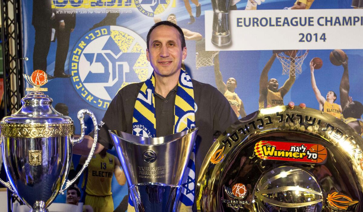 New Cavaliers Coach David Blatt poses with some of the trophies he won with Maccabi Tel Aviv at a news conference in Israel announcing his departure from the club for the NBA.
