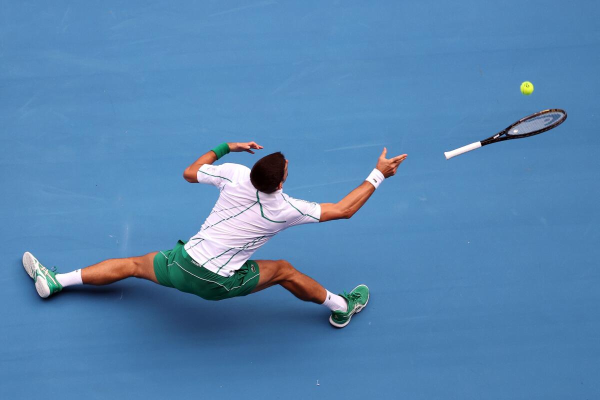 TOPSHOT - Serbia's Novak Djokovic loses his racket as he tries to hit a return against Japan's Tatsuma Ito during their men's singles match on day three of the Australian Open tennis tournament in Melbourne on January 22, 2020. (Photo by DAVID GRAY / AFP) / IMAGE RESTRICTED TO EDITORIAL USE - STRICTLY NO COMMERCIAL USE (Photo by DAVID GRAY/AFP via Getty Images) ** OUTS - ELSENT, FPG, CM - OUTS * NM, PH, VA if sourced by CT, LA or MoD **