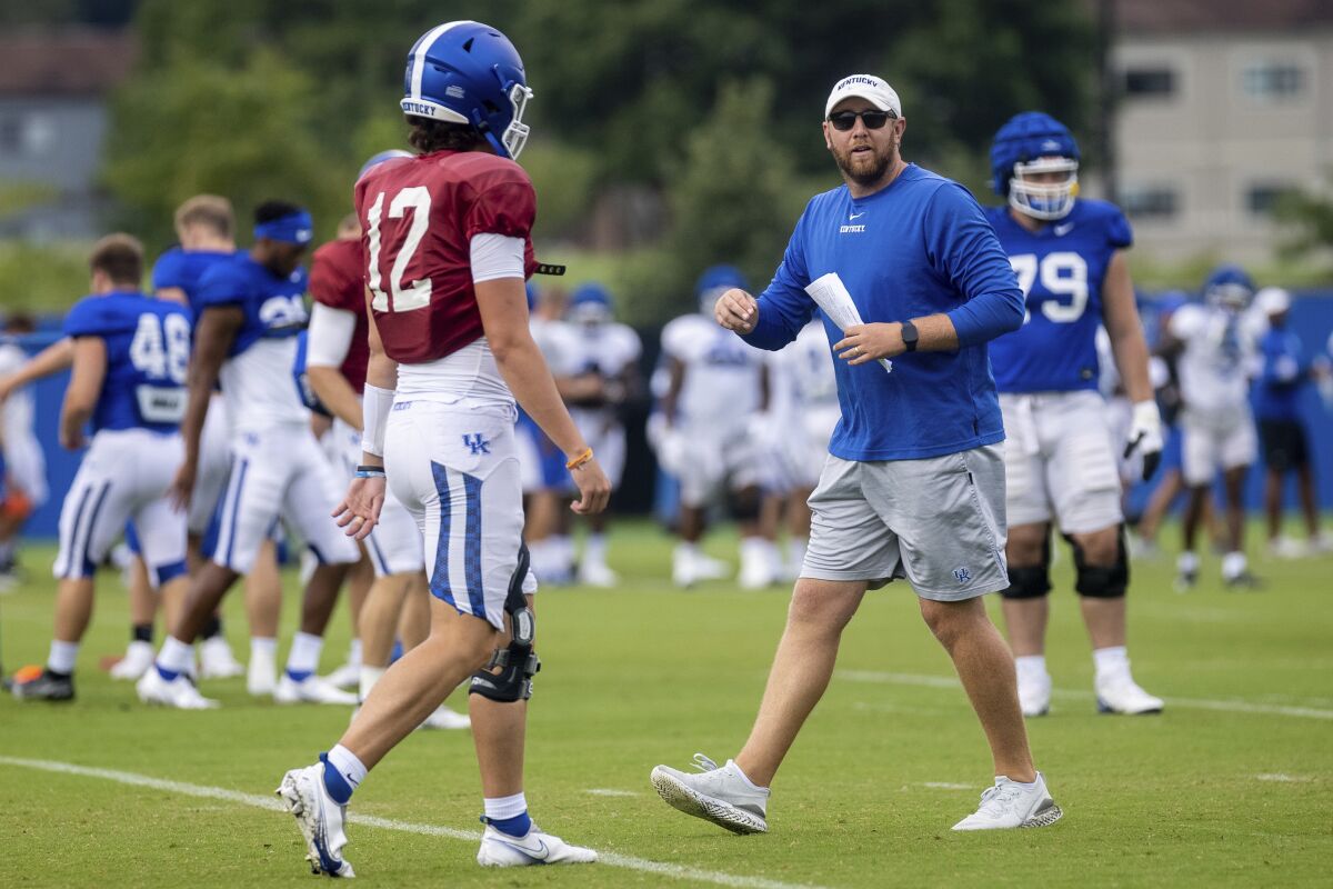 Kentucky offensive coordinator Liam Coen runs a drill during practice.