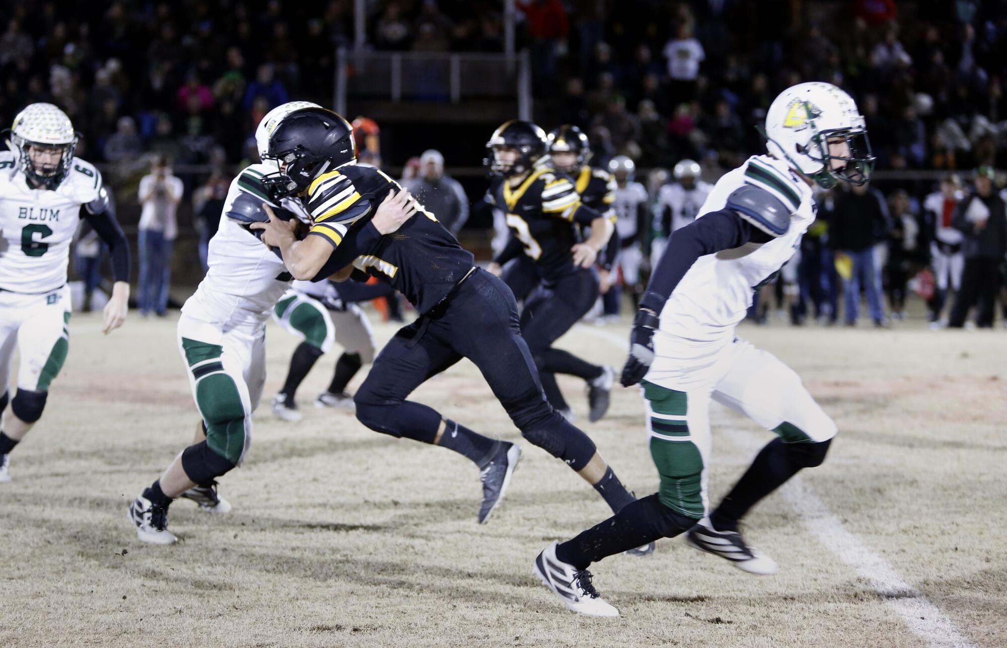 Jonesboro (in black) goes head to head with Blum. Six-man football is a wide-open game in which every player is an eligible receiver. High-scoring games are the norm.