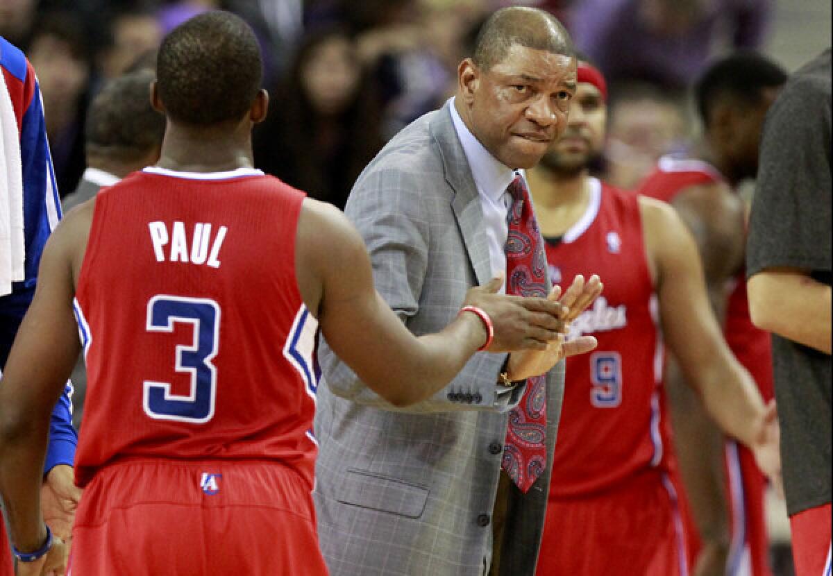 Coach Doc Rivers gives point guard Chris Paul five as the Clippers gather for a timeout in the closing seconds of a 110-101 victory over the Kings in Sacramento on Friday night.
