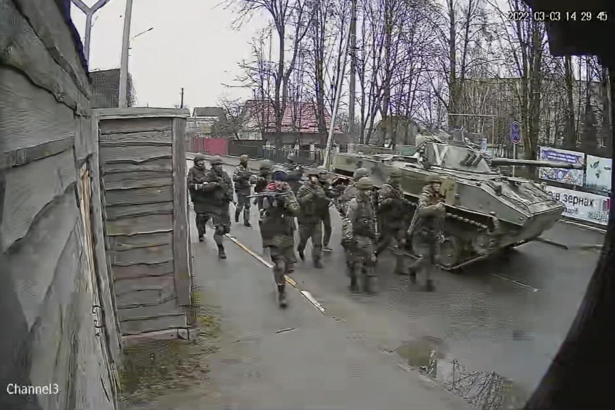 In an image from surveillance video, Russian troops take over Yablunska Street in Bucha, Ukraine.