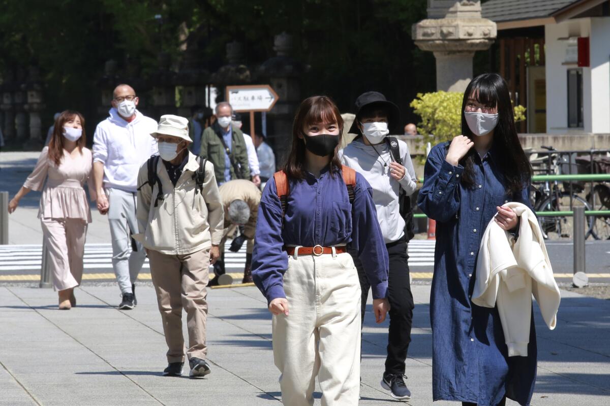Personas con cubrebocas por el coronavirus visitan el santuario Yasukuni en Tokio.