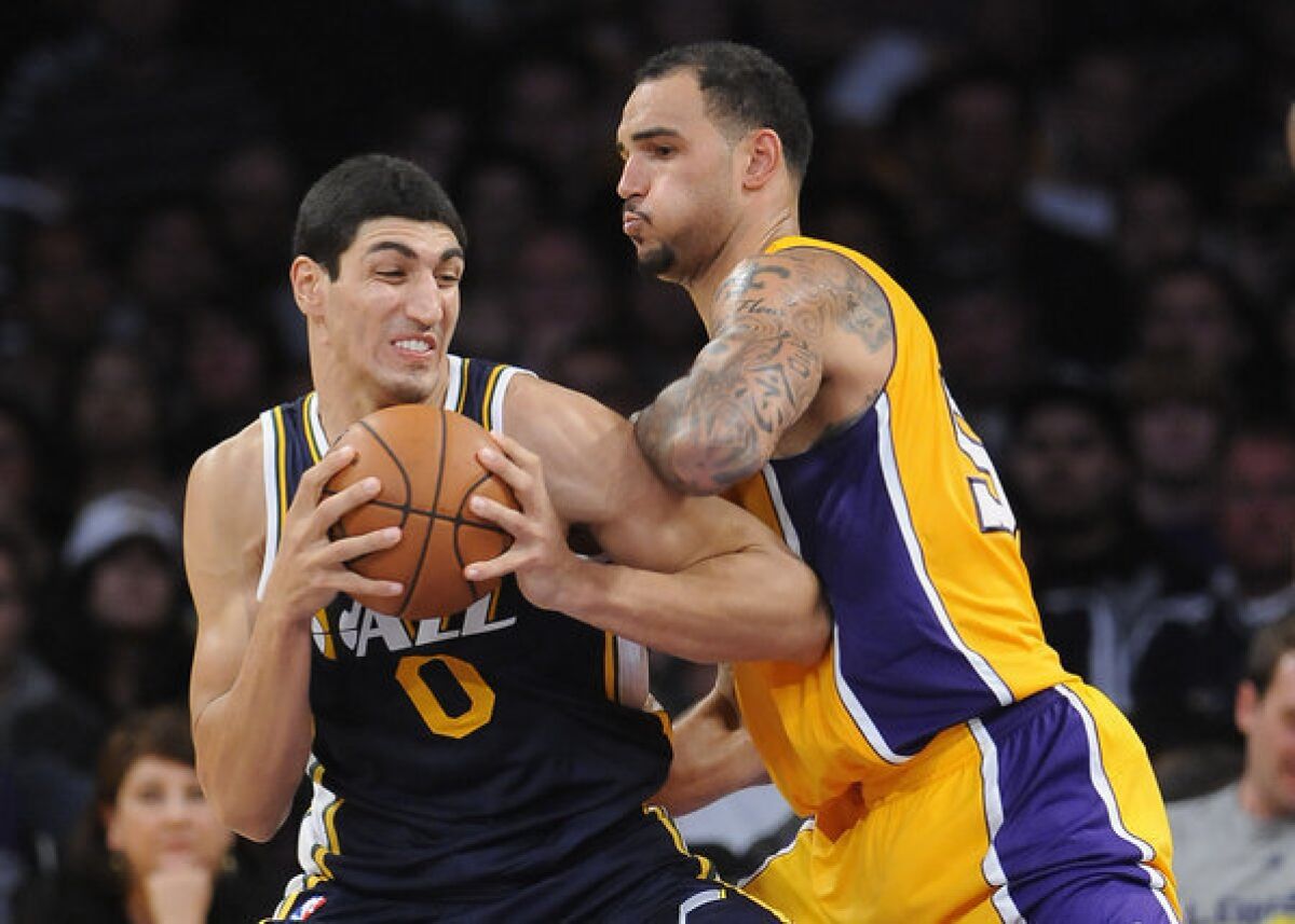 Lakers rookie center Robert Sacre tries to hold his position as Jazz center Enes Kanter works in the post during an exhibition game.