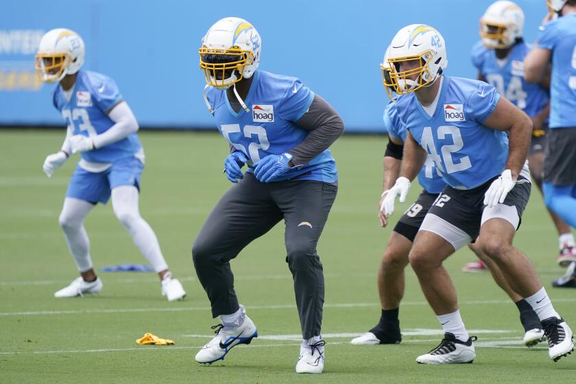 Los Angeles Chargers linebackers Khalil Mack, center, and Troy Reeder, right, warm up at the NFL football team's practice facility Tuesday, June 14, 2022, in Costa Mesa, Calif. (AP Photo/Marcio Jose Sanchez)