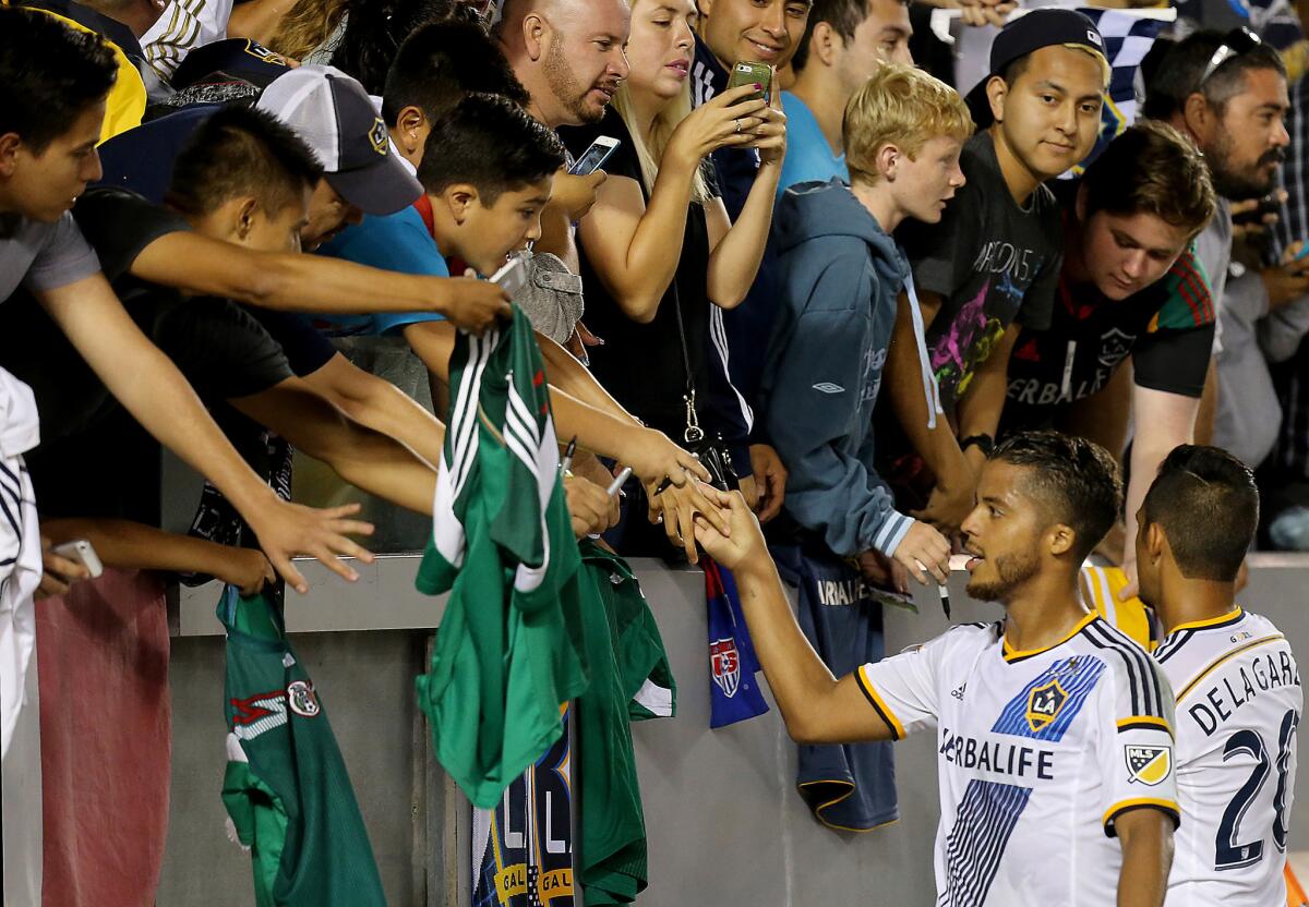 Forward Giovani Dos Santos shakes hands with fans following a victory over Central FC in his debut with the Galaxy.
