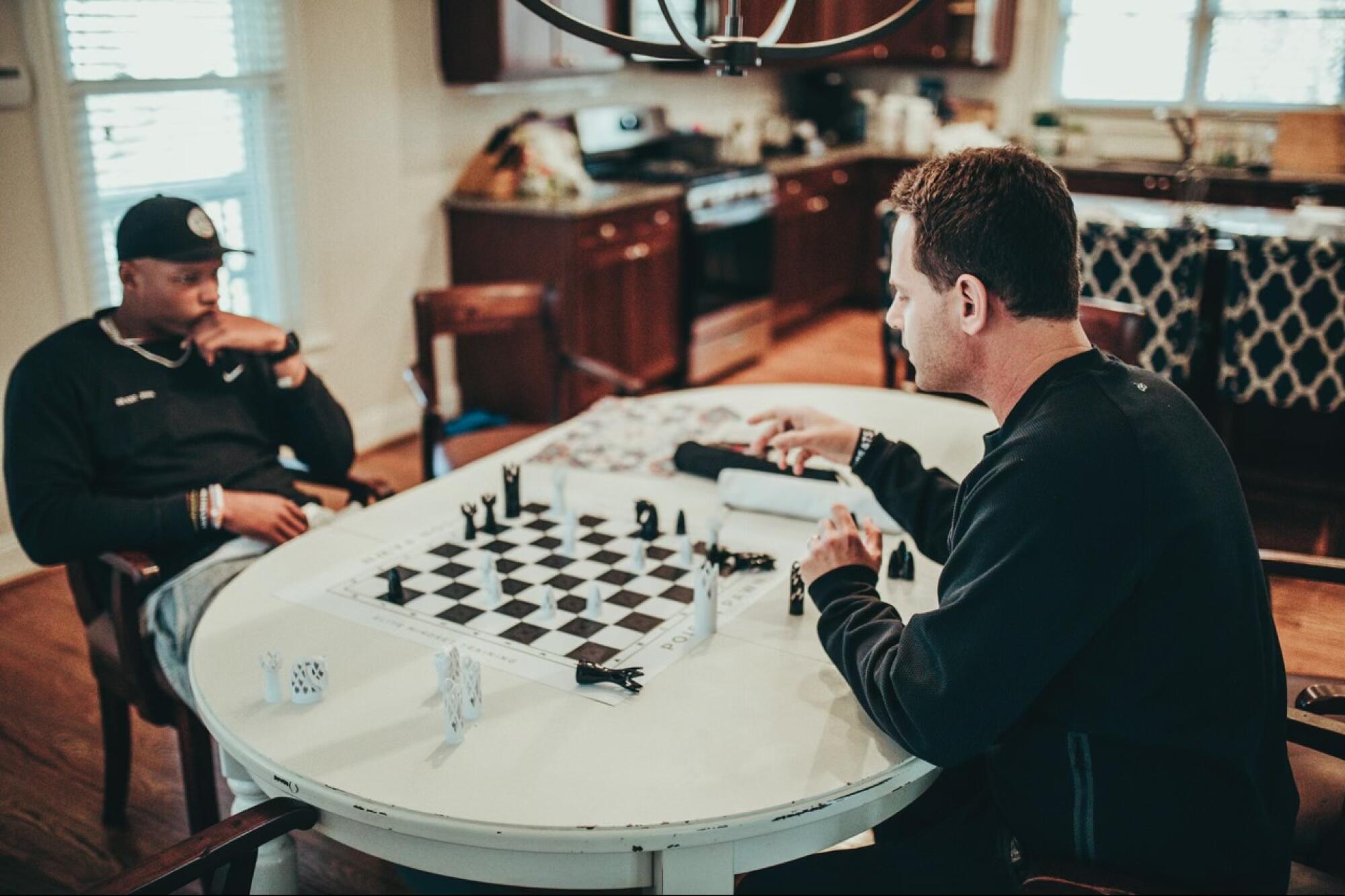 Josh Dobbs, left, quarterback for the Arizona Cardinals, plays chess with Seth Makowsky.