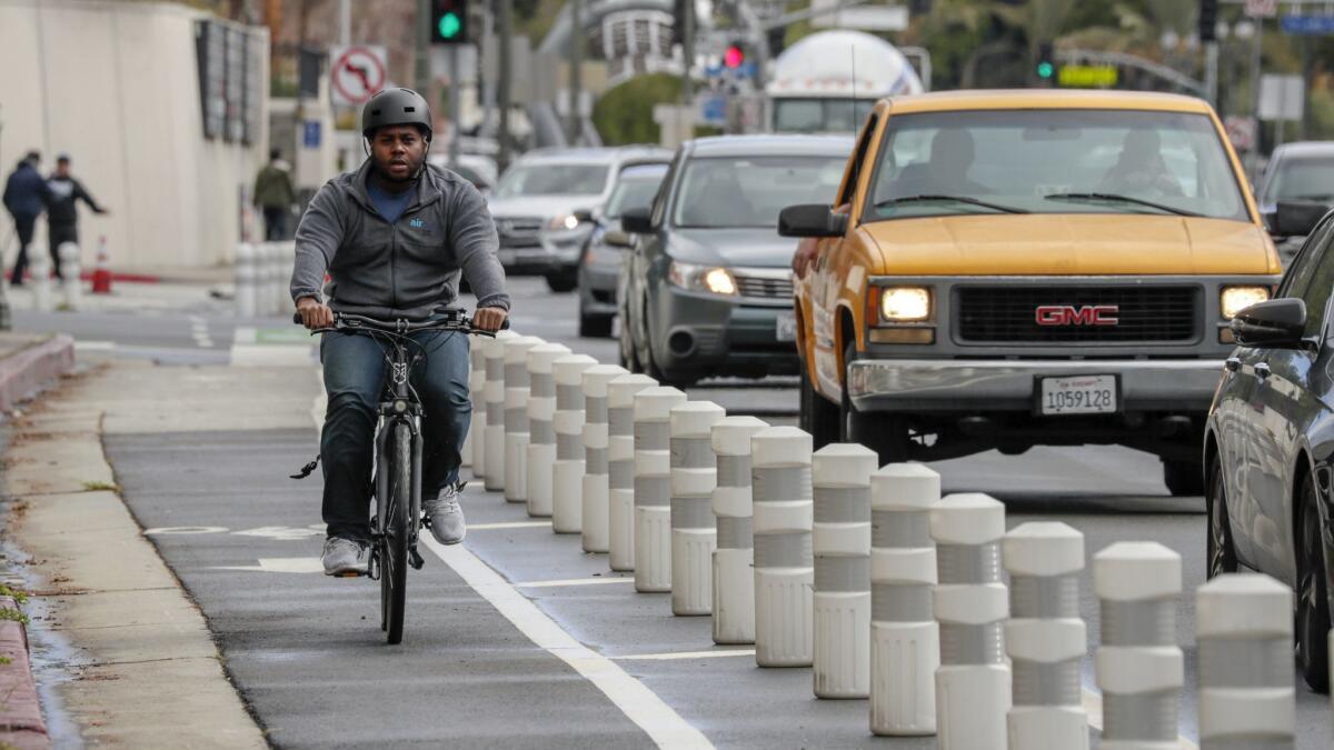 A bicyclist rides along Los Angeles Street near Temple where features have been added in an effort to reduce crashes. The mayor plans to spend $90.4 million on projects aimed at making the city less lethal for drivers, bicyclists and pedestrians.
