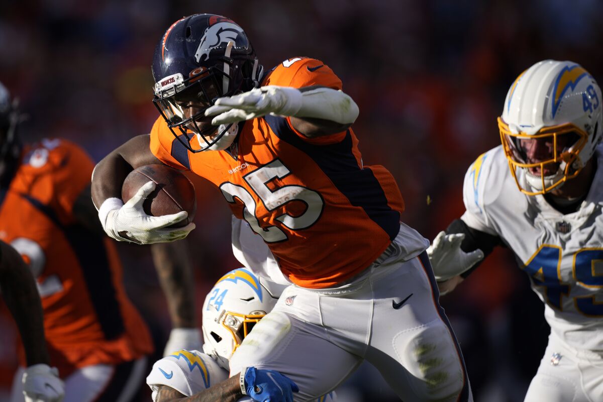 Denver Broncos running back Melvin Gordon (25) runs as Los Angeles Chargers middle linebacker Drue Tranquill (49) pursues during the first half of an NFL football game, Sunday, Nov. 28, 2021, in Denver. (AP Photo/David Zalubowski)