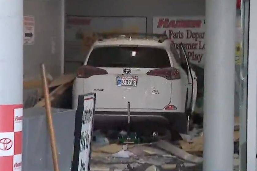 A car sits in the debris after it drove through the Hamer Toyota dealership in Mission Hills after a fatal crash.