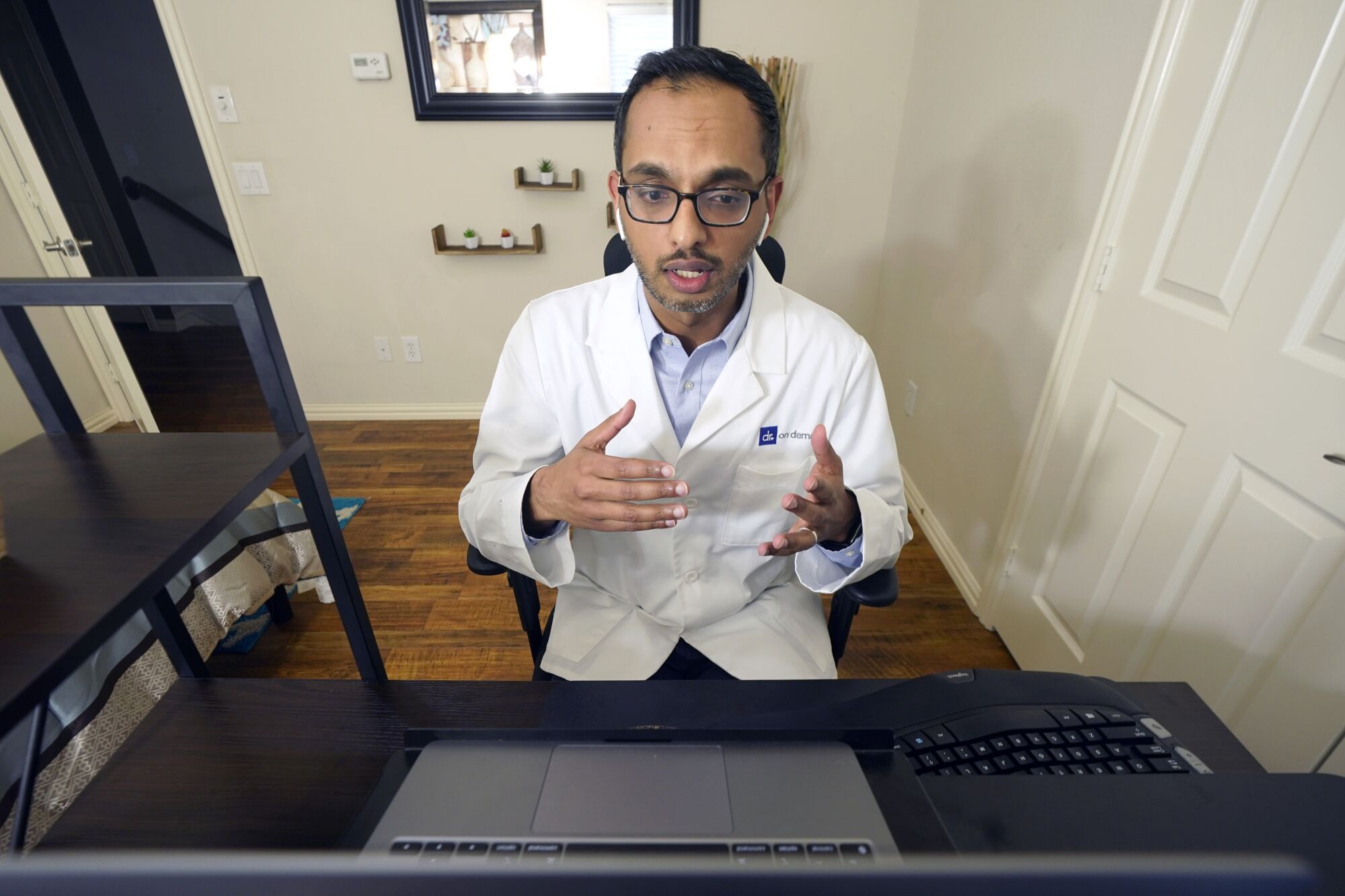 Dr. Vibin Roy speaks to a patient during an online primary care visit from his home in Keller, Texas. 