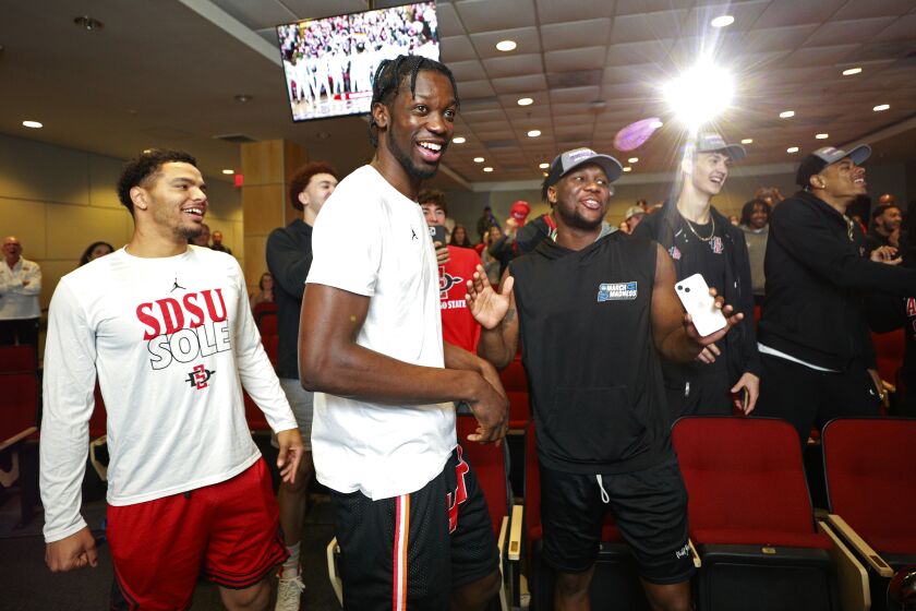 San Diego, CA - March 11: The San Diego State men's basketball team celebrates after their NCAA tournament announcement on Sunday, March 12, 2023. The Aztecs will play Charleston in Orlando. From left are Matt Bradley, Nathan Mensah, and Adam Seiko. (K.C. Alfred / The San Diego Union-Tribune)