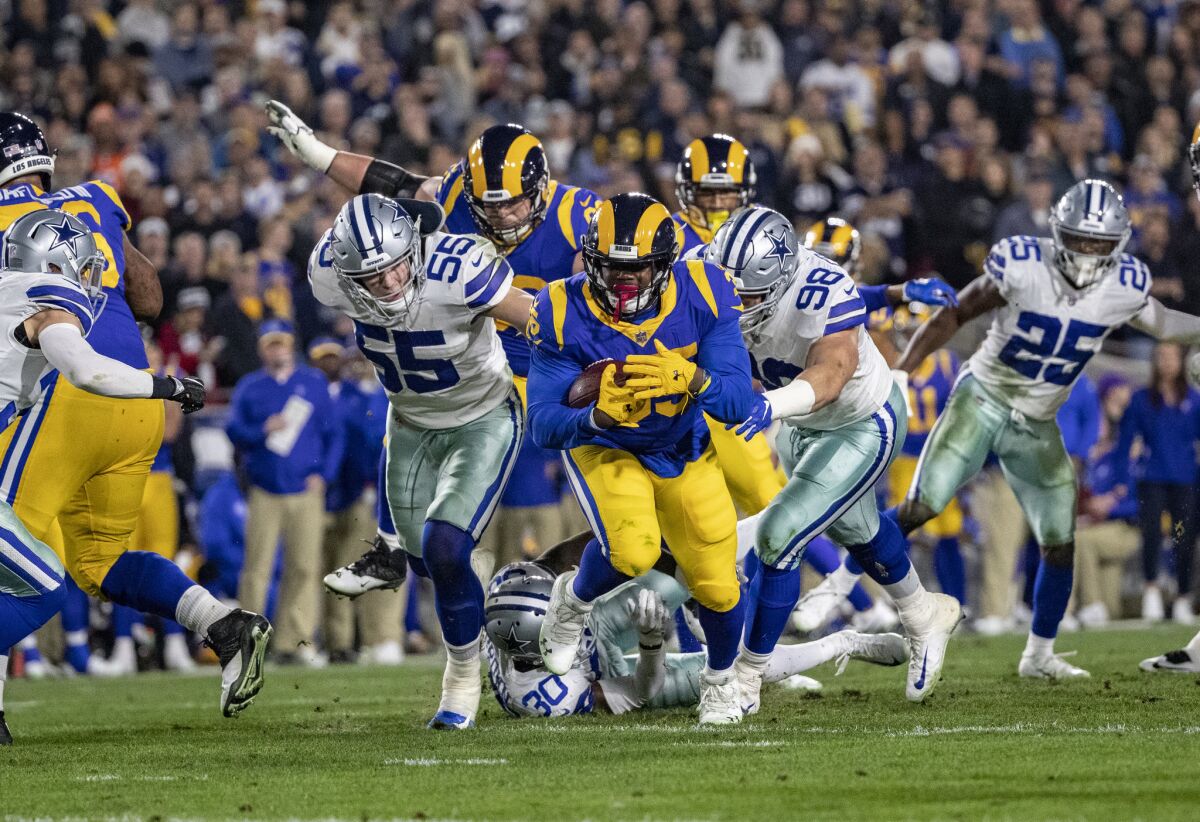Rams running back C.J. Anderson (35) breaks through a big hole for a gain against the Cowboys during the first half Saturday