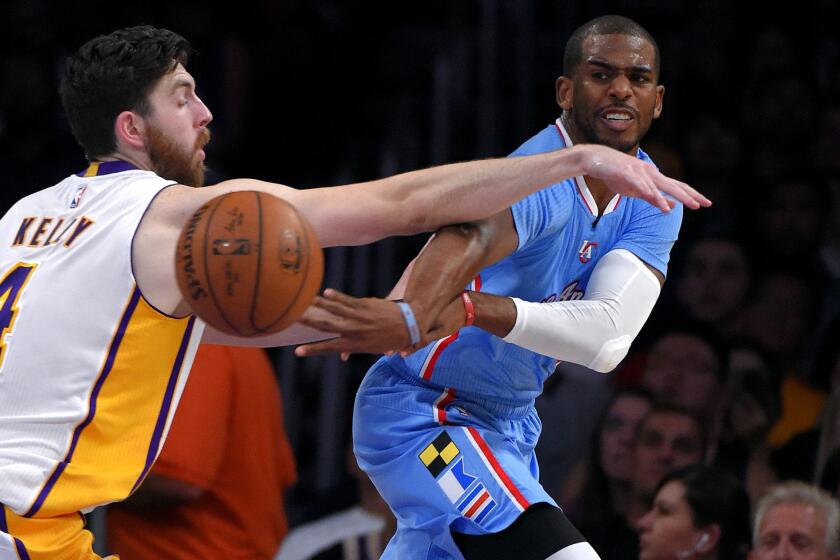 Clippers point guard Chris Paul flips a pass around Lakers forward Ryan Kelly in the first half Sunday night at Staples Center.