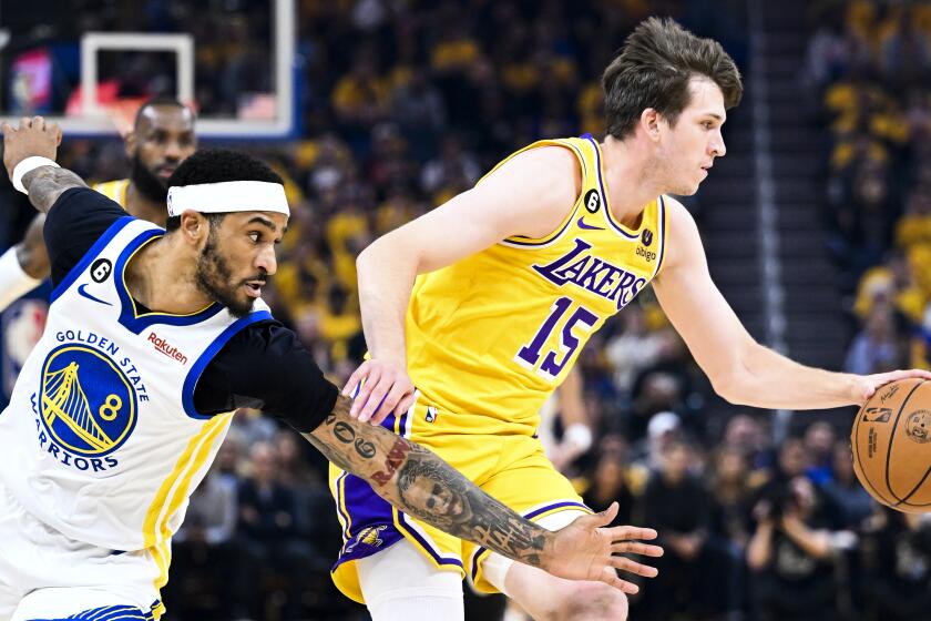 SAN FRANCISCO, CA - MAY 10: Golden State Warriors guard Gary Payton II, left, lunges for the ball against Los Angeles Lakers guard Austin Reaves during the first half of game five of the NBA Playoffs Western Conference Semifinals at Chase Center on Wednesday, May 10, 2023 in San Francisco, CA. (Wally Skalij / Los Angeles Times)