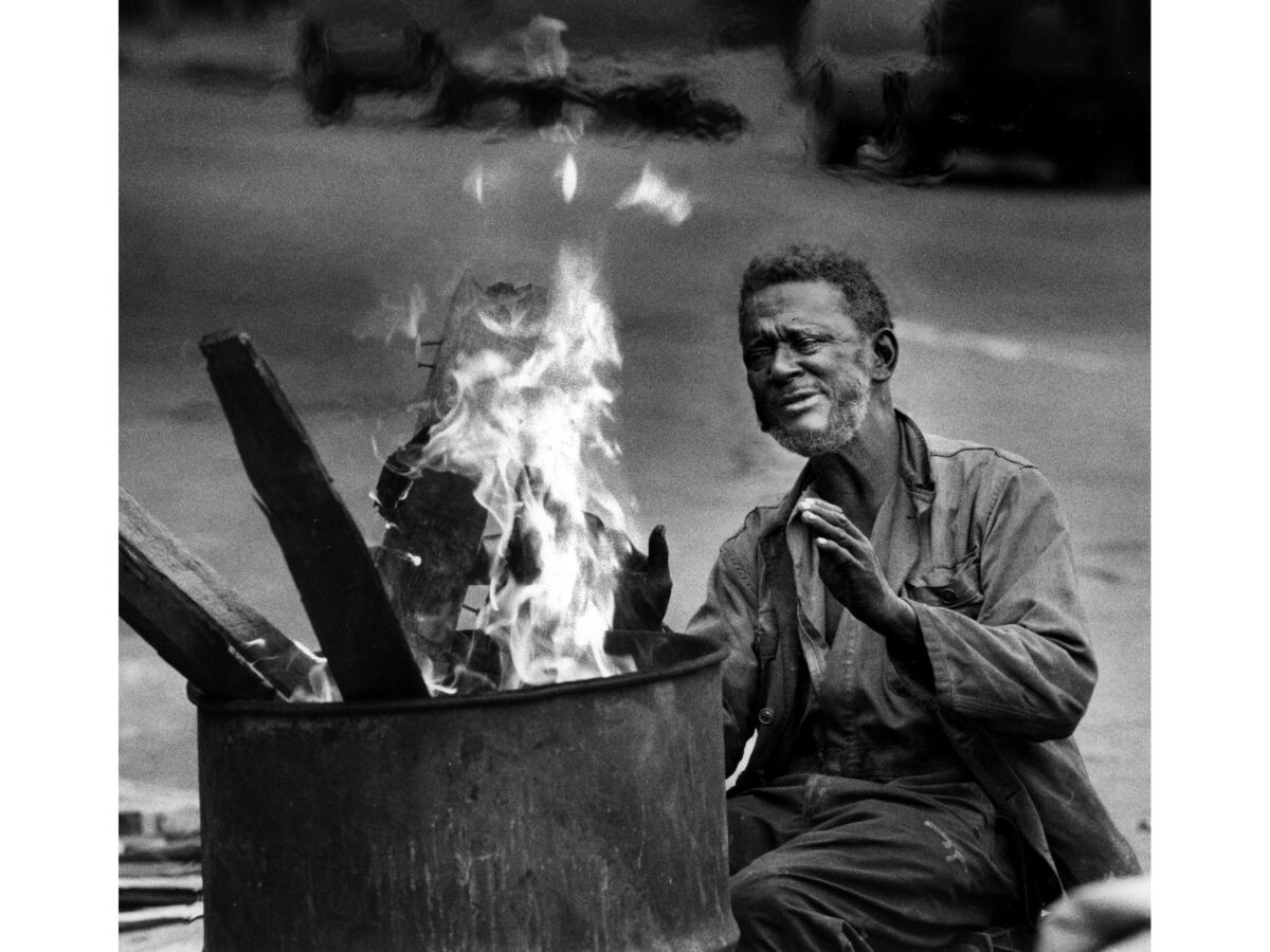 Dec. 28, 1988: Audridge Robertson keeps warm by a fire in downtown Los Angeles.