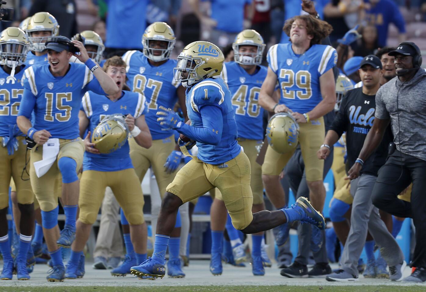 UCLA's Darnay Holmes returns a Stanford kickoff for a touchdown during the third.